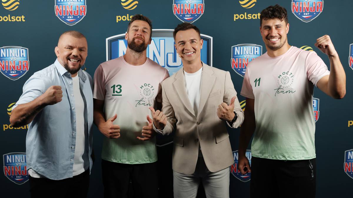 Czterech mężczyzn pozuje do zdjęcia, uśmiechając się do kamery. Wszyscy są ubrani w koszulki i stoją na tle logo programu "Ninja vs Ninja".