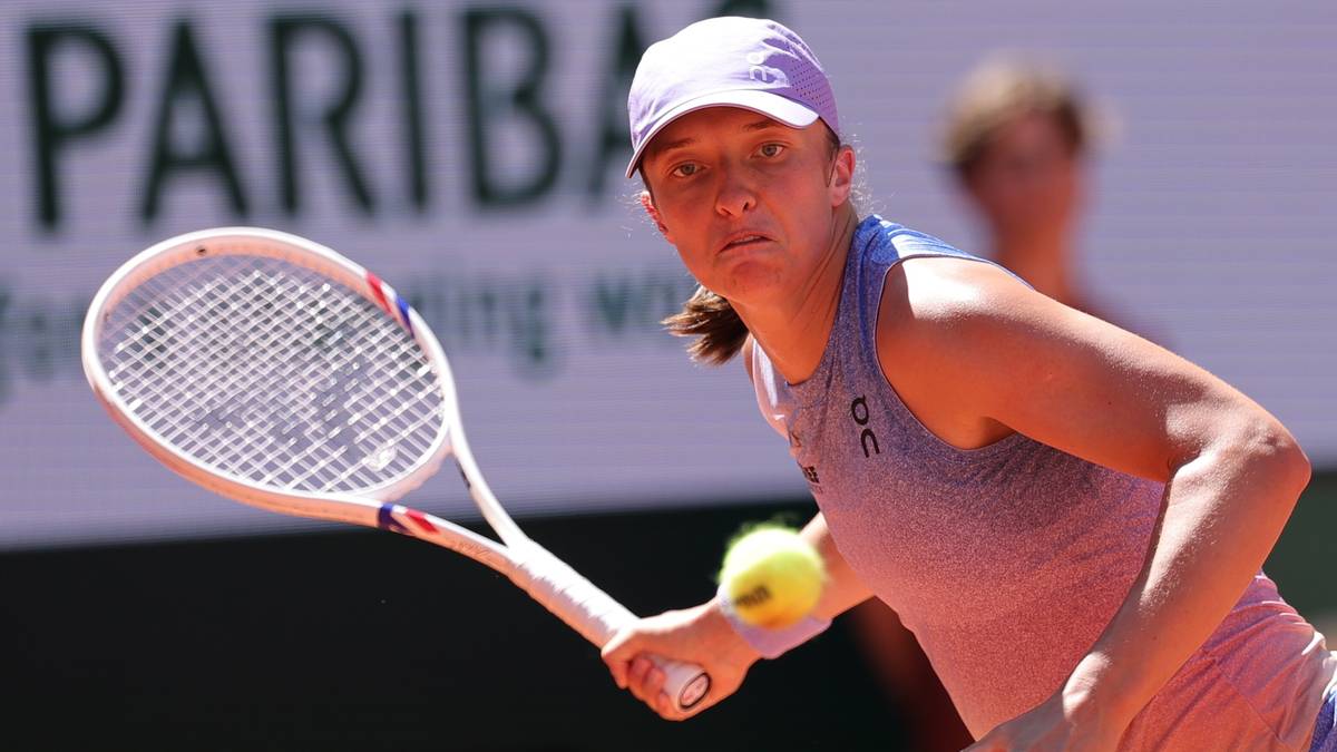 Iga Świątek, polska tenisistka, uderza piłkę rakietą podczas meczu.