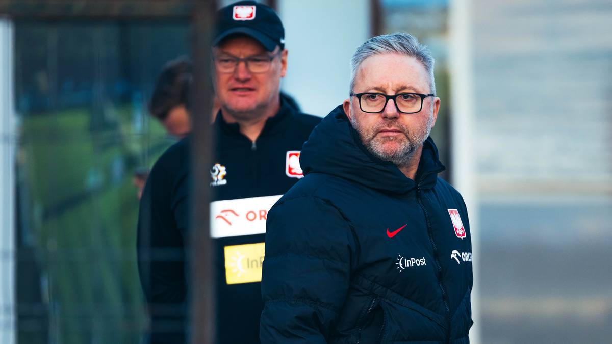 Dw&oacute;ch mężczyzn w strojach reprezentacji Polski, jeden w czapce z daszkiem, drugi w okularach.