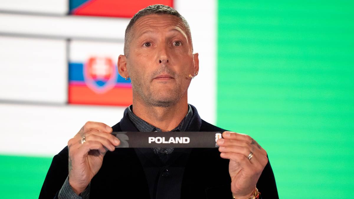 Mężczyzna trzyma wstążkę z napisem POLAND, z flagami w tle.