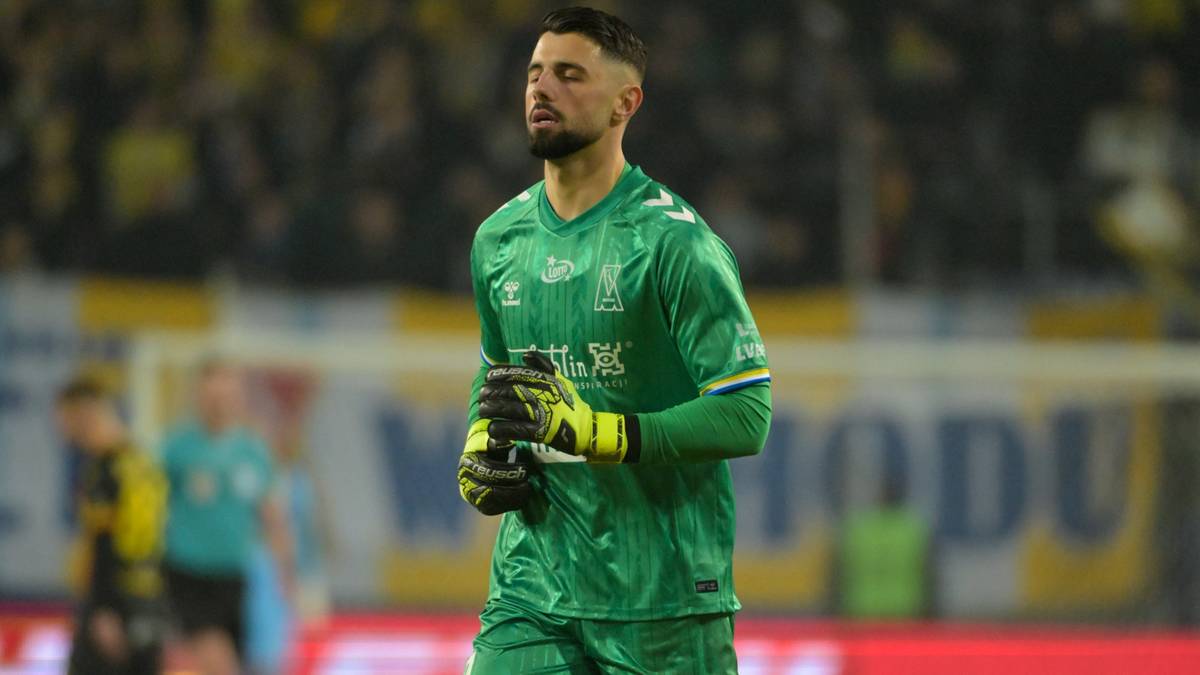 Bramkarz Motoru Lublin w zielonym stroju bramkarskim z rękawicami w rękach.