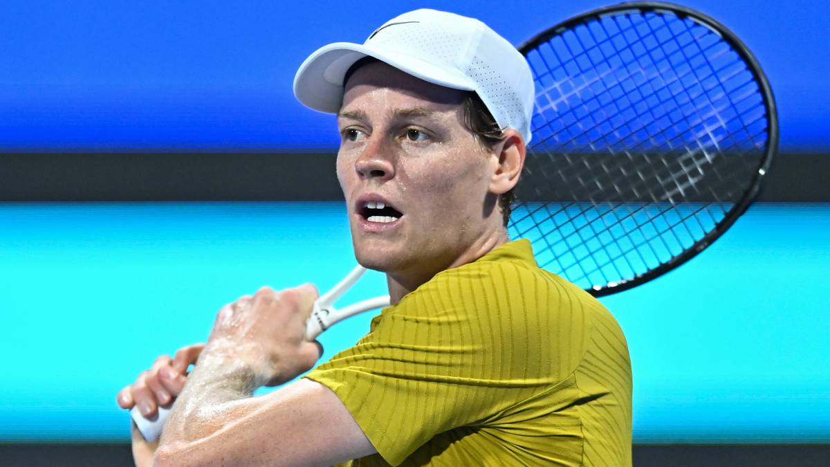 Jannik Sinner podczas meczu tenisowego, trzymający rakietę i patrzący w stronę przeciwnika.
