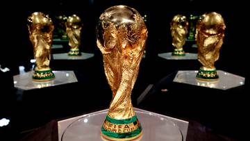 Złoty Puchar Świata FIFA na pierwszym planie, z innymi pucharami w tle.