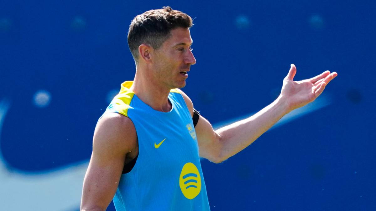 Piłkarz Robert Lewandowski w niebieskiej koszulce z ż&oacute;łtym logo na tle niebieskiego tła z białym logo Nike.