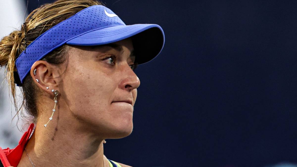 Portret tenisistki Pauli Badosy z niebieską czapką z daszkiem i widocznym kolczykiem.