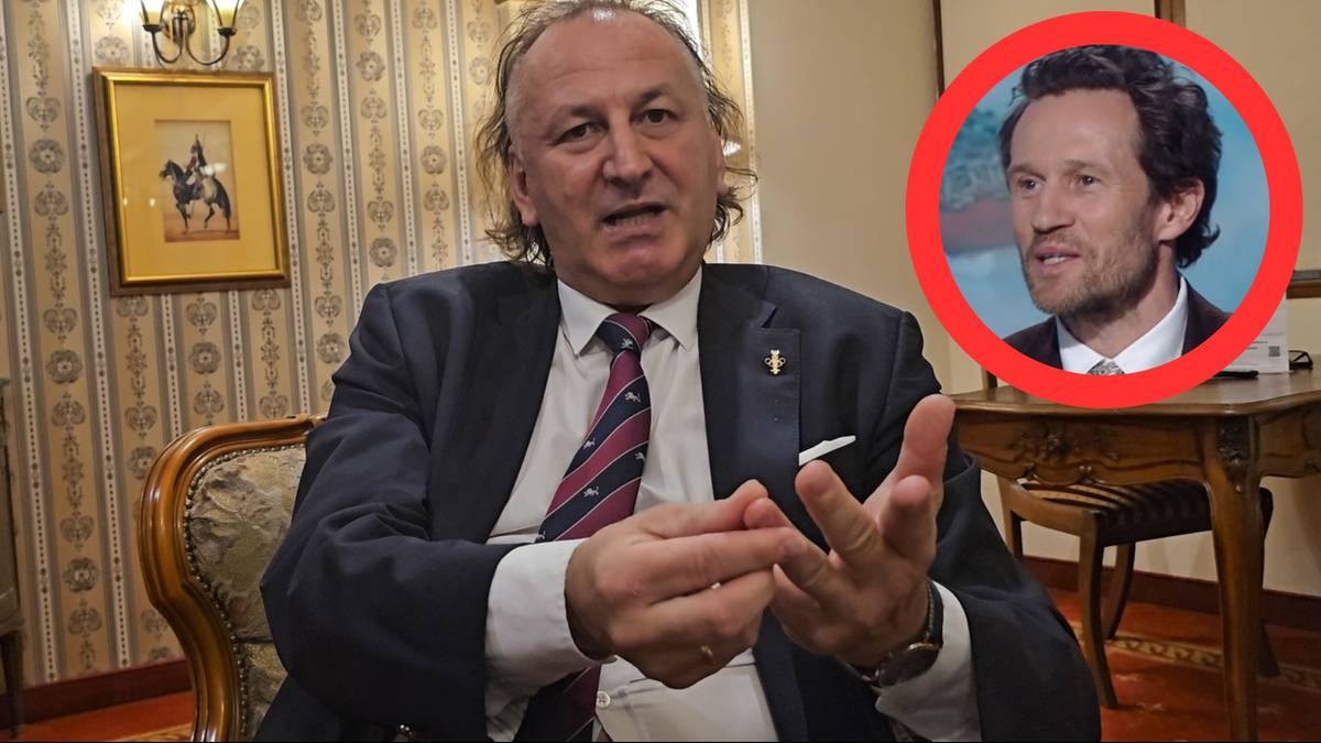 Mężczyzna w garniturze mówi gestykulując, w tle obraz na ścianie. W prawym górnym rogu, w czerwonym okręgu, portret innego mężczyzny.