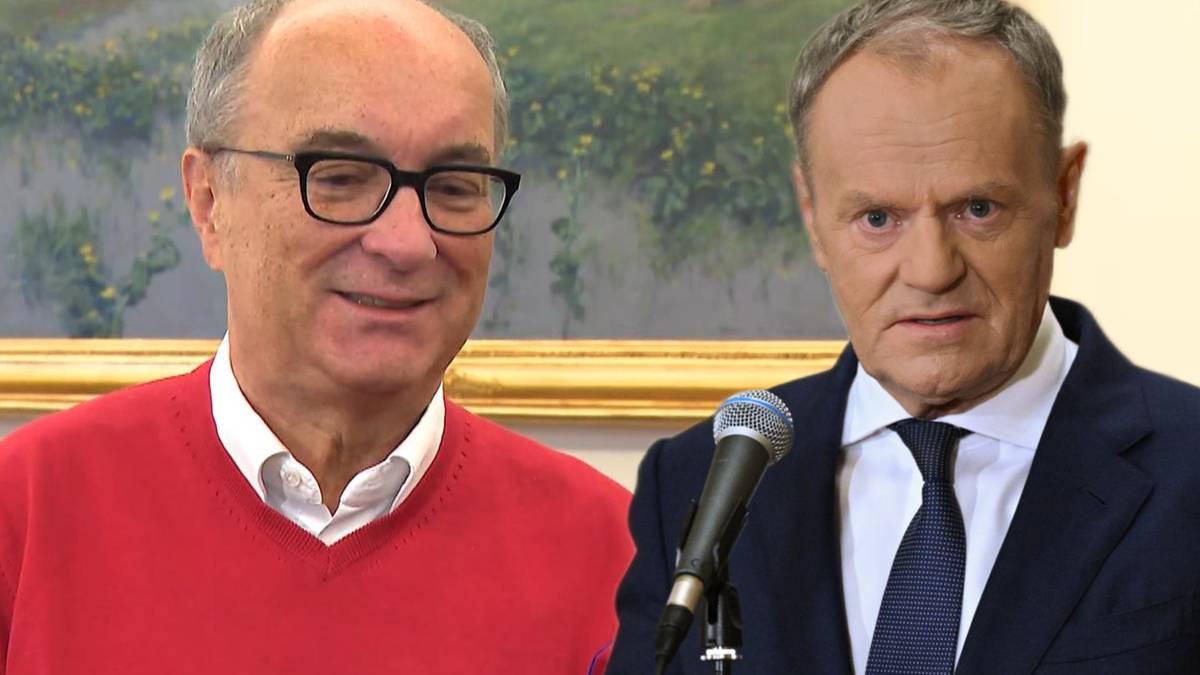 Dw&oacute;ch mężczyzn, jeden w czerwonym swetrze i okularach, drugi w garniturze i krawacie, stoją obok siebie.