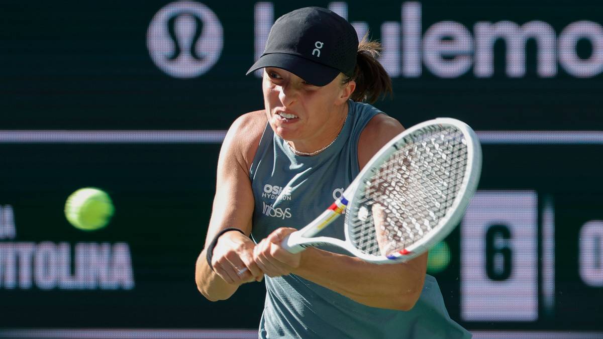 Tenisistka Iga Świątek podczas uderzenia rakietą, skupiona na piłce tenisowej.