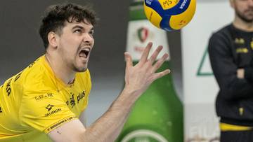 Siatkarz w żółtej koszulce z piłką do siatkówki w powietrzu.