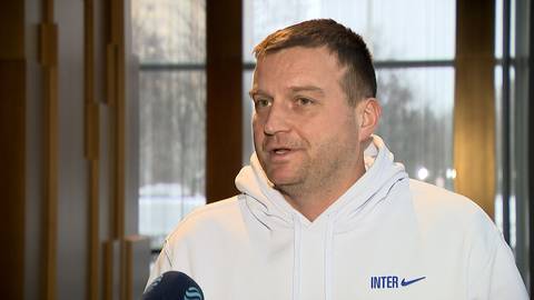 Dawid Olejniczak w białej bluzie z napisem INTER, trzymający mikrofon.