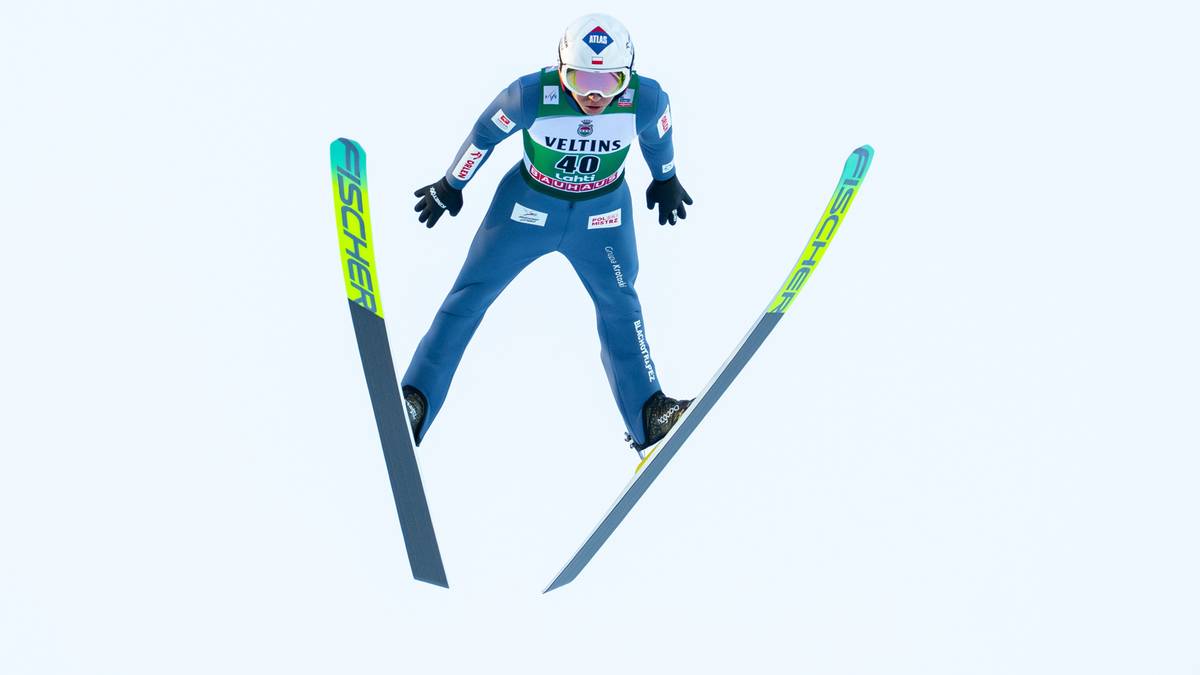 Skoczek narciarski w locie na nartach z tyczkami