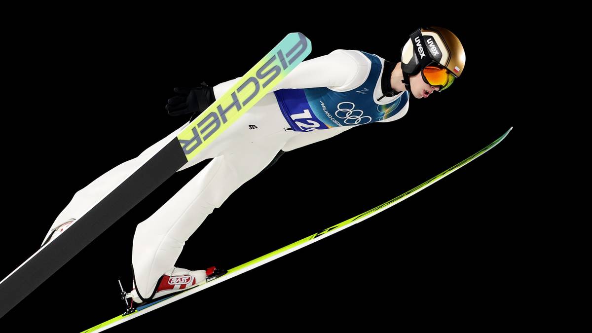 Skoczek narciarski Kacper Tomasiak w locie na nartach.