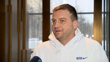 Dawid Olejniczak w białej bluzie z napisem INTER, trzymający mikrofon.
