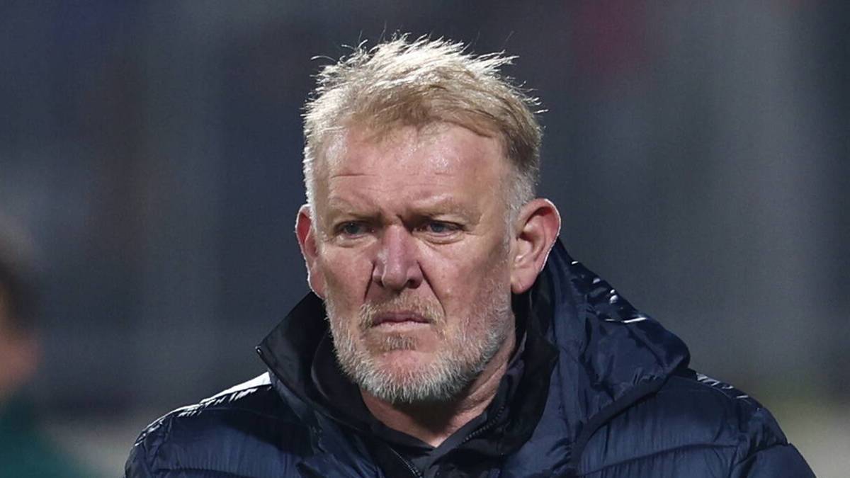 Portret mężczyzny w średnim wieku z blond włosami i siwiejącą brodą, ubranego w ciemną kurtkę.