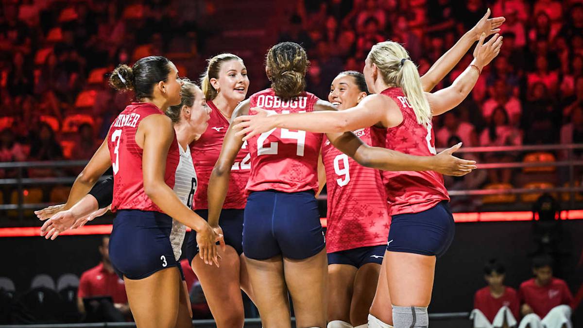 Druzyna siatkarek w czerwonych strojach świętuje zjednoczona, pokazując wsparcie i radość po zwycięstwie.