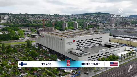 Widok z drona na budynek areny sportowej z widocznym pasem informacyjnym "FINLAND" - "UNITED STATES".