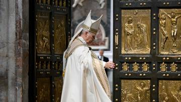 Papież w białych szatach i mitrze zamyka złote, ozdobne drzwi.