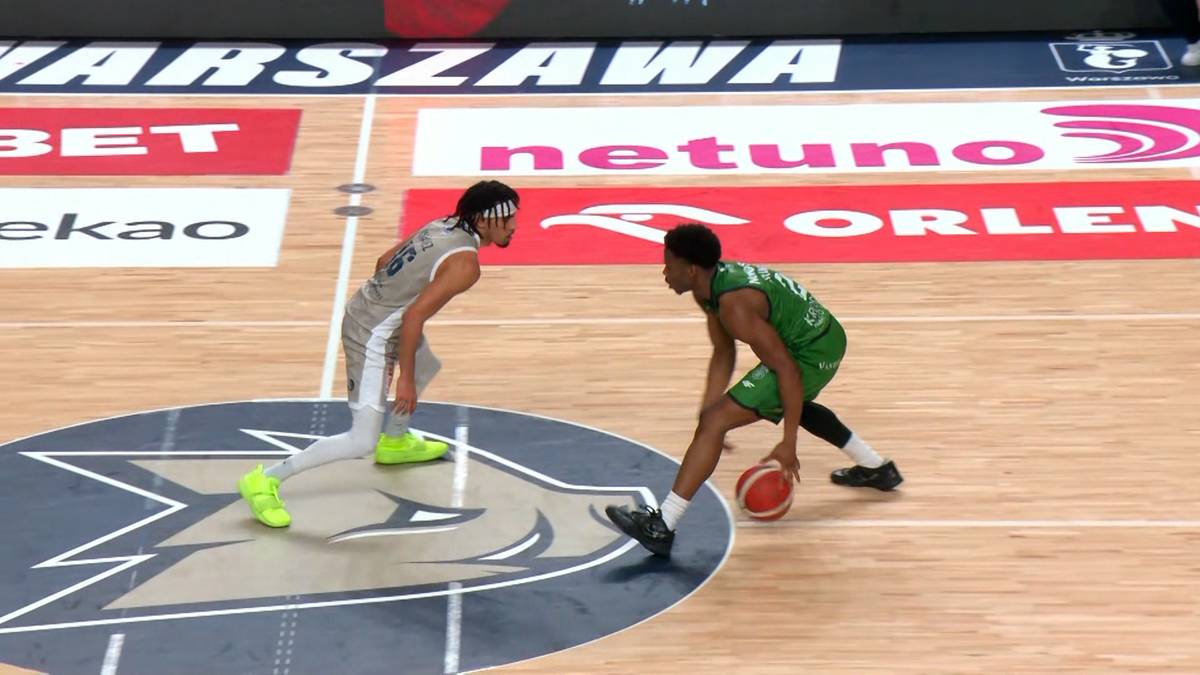 Dw&oacute;ch zawodnik&oacute;w koszyk&oacute;wki rywalizuje o piłkę na parkiecie z logo drużyny.