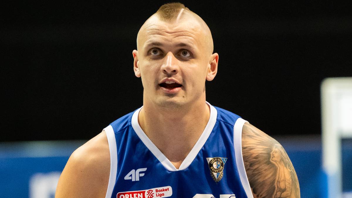 Portret mężczyzny w koszulce drużyny koszykarskiej Górnik Zamek Książ, z charakterystycznym irokezem na głowie.