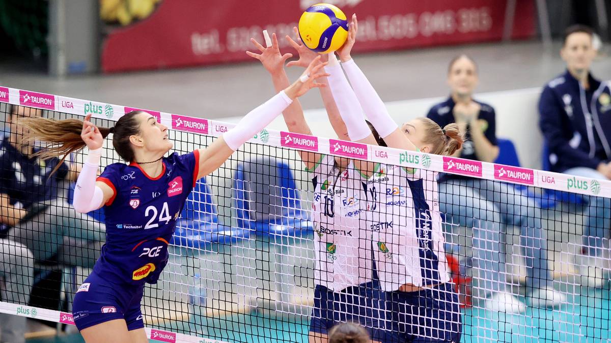 Dwie siatkarki walczą przy siatce o piłkę podczas meczu.