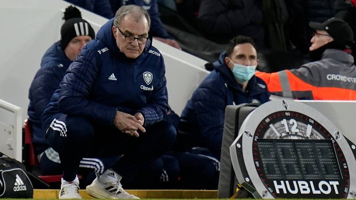 Marcelo Bielsa w niebieskiej kurtce siedzi na ławce rezerwowych.