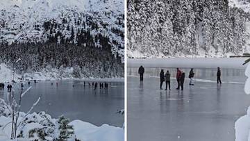 Ludzie spacerujący i bawiący się na cienkiej warstwie lodu na zamarzniętym Morskim Oku w Tatrach, otoczeni ośnieżonymi górami i lasem.