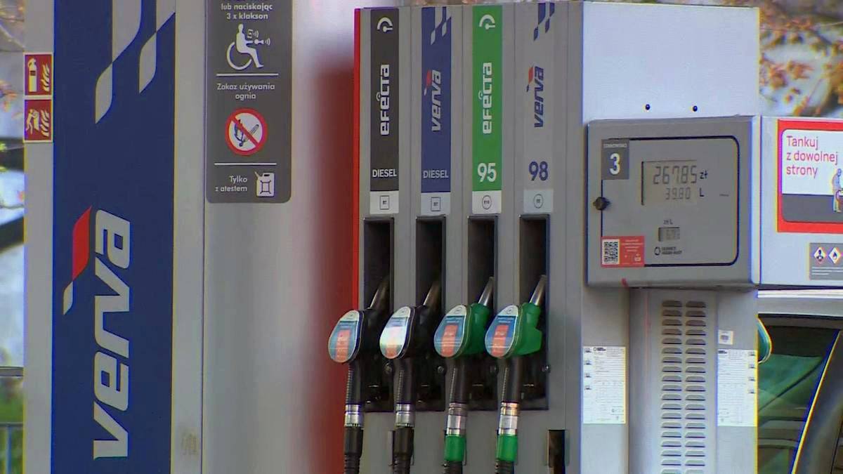 Dystrybutor paliw na stacji benzynowej z czteroma pistoletami w uchwytach i wyświetlaczem.