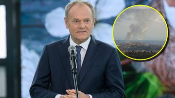 Donald Tusk przemawia, w tle widoczne fragmenty tła, w prawym g&oacute;rnym rogu okrągła wstawka z obrazem dymiących budynk&oacute;w.