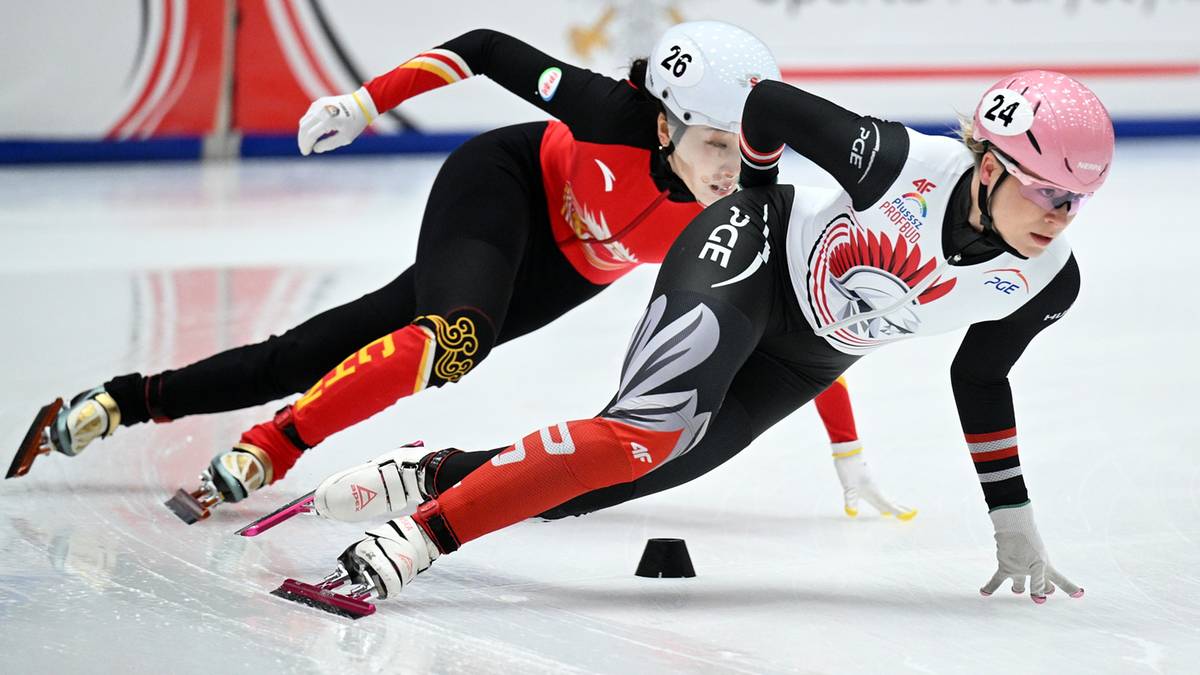 Dwie zawodniczki short tracka w trakcie wyścigu na lodowisku.