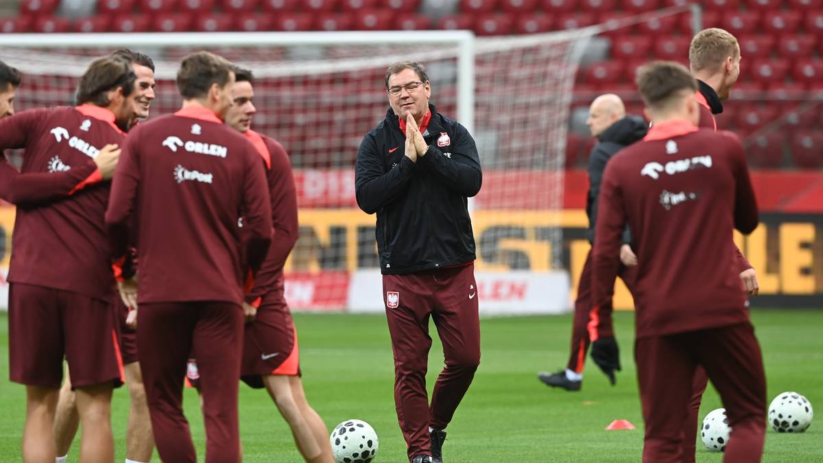 Trener piłkarskiej reprezentacji Polski Michał Probierz w otoczeniu zawodników na murawie stadionu.