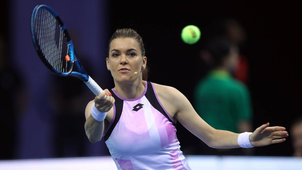 Kobieta grająca w tenisa, uderzająca piłkę rakietą.