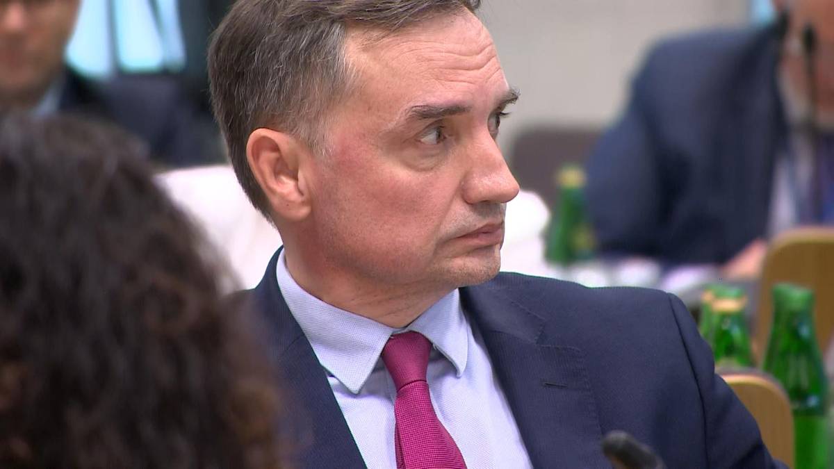 Zbigniew Ziobro siedzi w garniturze i krawacie, patrząc w bok.