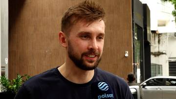 Portret Mateusza Bieńka, siatkarza reprezentacji Polski, z bliska. Ma kr&oacute;tkie, brązowe włosy i zarost. Na jego koszulce widoczne jest logo Polsatu.