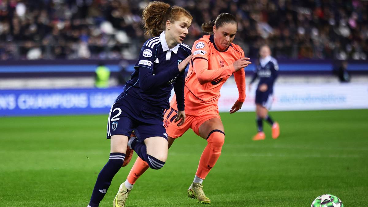 Dwie piłkarki w akcji na boisku, jedna w niebieskim stroju z numerem 22, druga w pomarańczowym stroju, ścigają się do piłki.