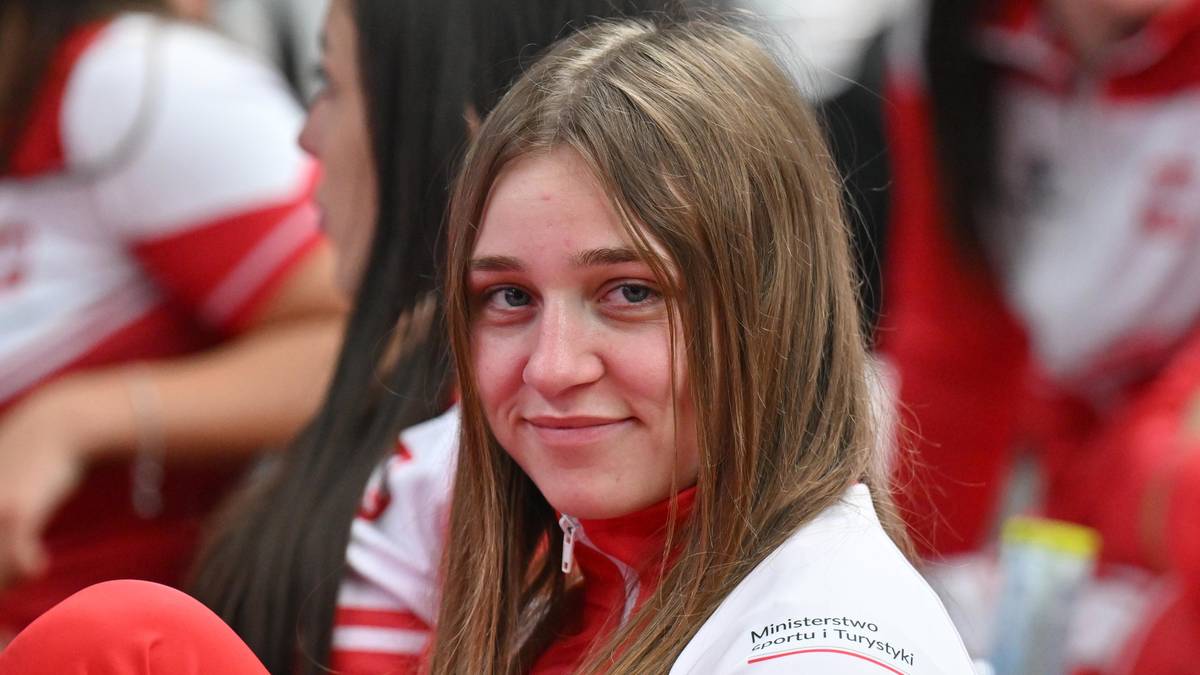 Młoda kobieta w biało-czerwonym stroju sportowym.