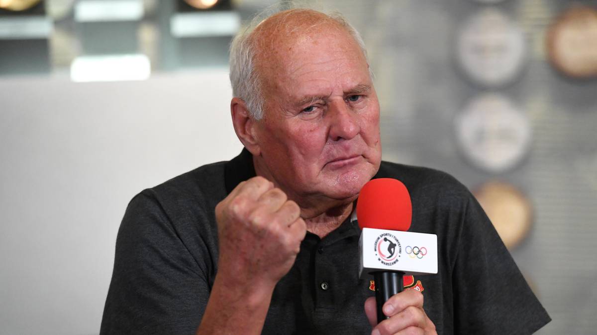 Starszy mężczyzna z zaciśniętą pięścią mówi do mikrofonu.