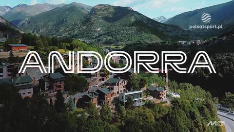 Widok z lotu ptaka na g&oacute;rską miejscowość z budynkami i otaczającymi ją wzg&oacute;rzami.