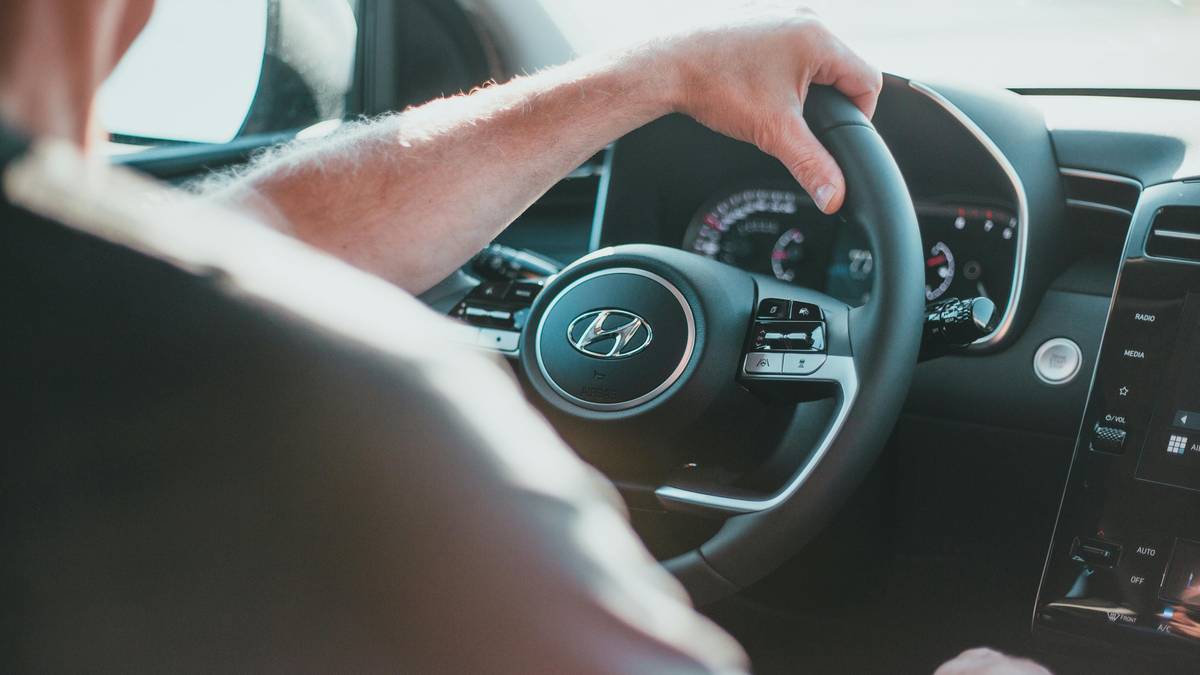 Dłoń kierowcy na kierownicy samochodu.