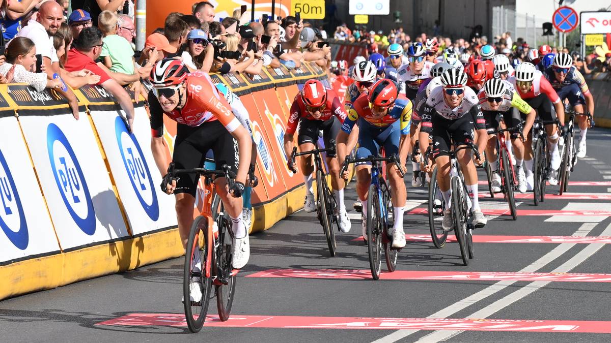Kolarz Ben Turner w czerwonym stroju prowadzi peleton podczas trzeciego etapu Tour de Pologne w Wałbrzychu.