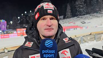 Maciej Maciusiak w czapce zimowej z polskim godłem i kurtce z logo Orlen udziela wywiadu z mikrofonem Polsat Sport.