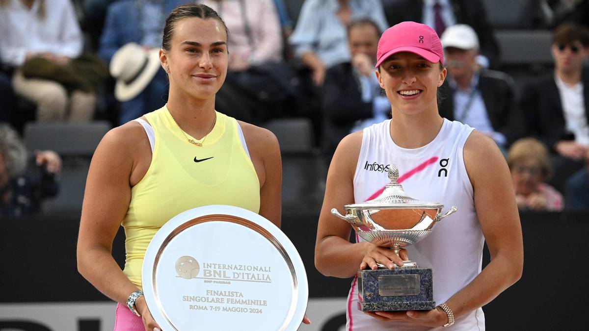 Dwie tenisistki, Iga Świątek i Aryna Sabalenka, pozują do zdjęcia z pucharami po finale turnieju tenisowego.