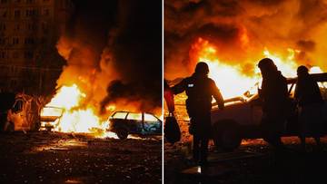 Płonące samochody i budynki w wyniku bombardowania, widoczne sylwetki ludzi