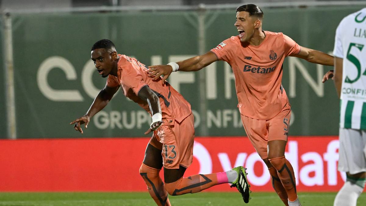 Dwóch piłkarzy w pomarańczowych strojach cieszy się po zdobyciu gola. Jeden piłkarz jest z przodu, jego ręka jest na ramieniu drugiego piłkarza, który biegnie z nim.