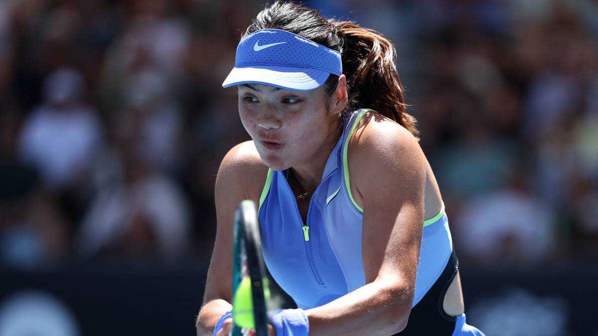 Tenisistka w niebieskiej czapce z daszkiem i stroju sportowym, skupiona podczas serwisu.