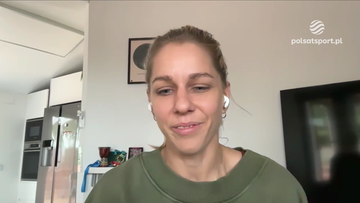 Aleksandra Mirosław podczas wywiadu, uśmiechnięta, w zielonej bluzie i słuchawkach dousznych.