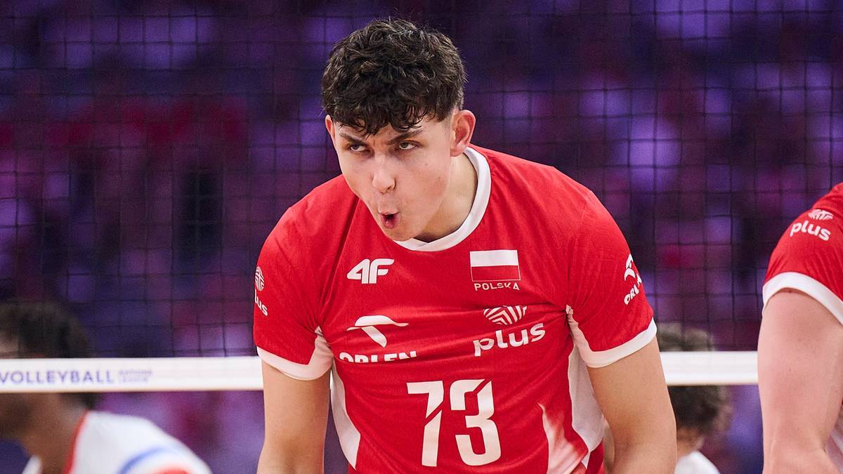 Siatkarz w czerwonej koszulce z numerem 73 i polską flagą, wyrażający emocje podczas meczu.
