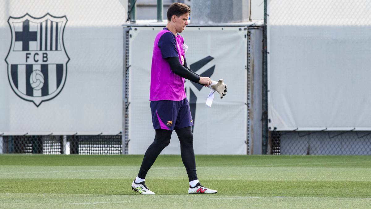 Piłkarz w stroju bramkarskim FC Barcelony, Wojciech Szczęsny, idzie po boisku z rękawicami w ręku.