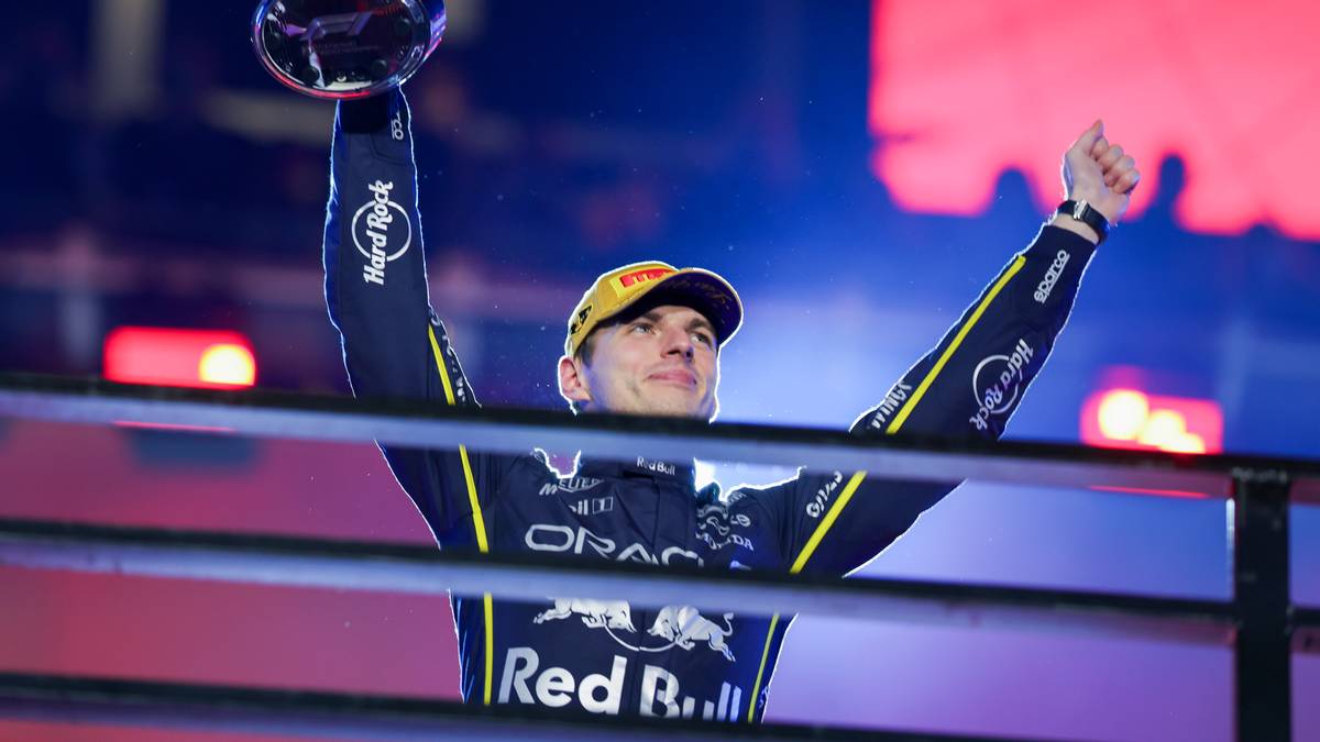 Max Verstappen unosi puchar nad głową, świętując zwycięstwo.