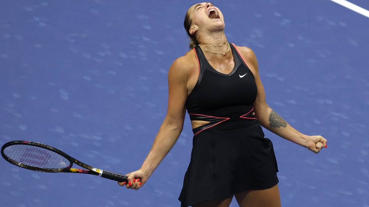 Aryna Sabalenka, tenisistka, z radości krzyczy po zdobyciu punktu, trzymając rakietę tenisową.