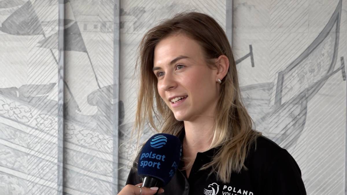 Kobieta z krótkimi blond włosami, ubrana w czarną bluzę z widocznym napisem "POLAND", udziela wywiadu, trzymając w dłoni mikrofon stacji Polsat Sport.